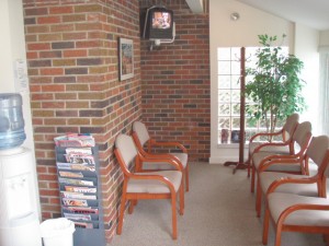 waiting room area with chairs, plants, and magazines